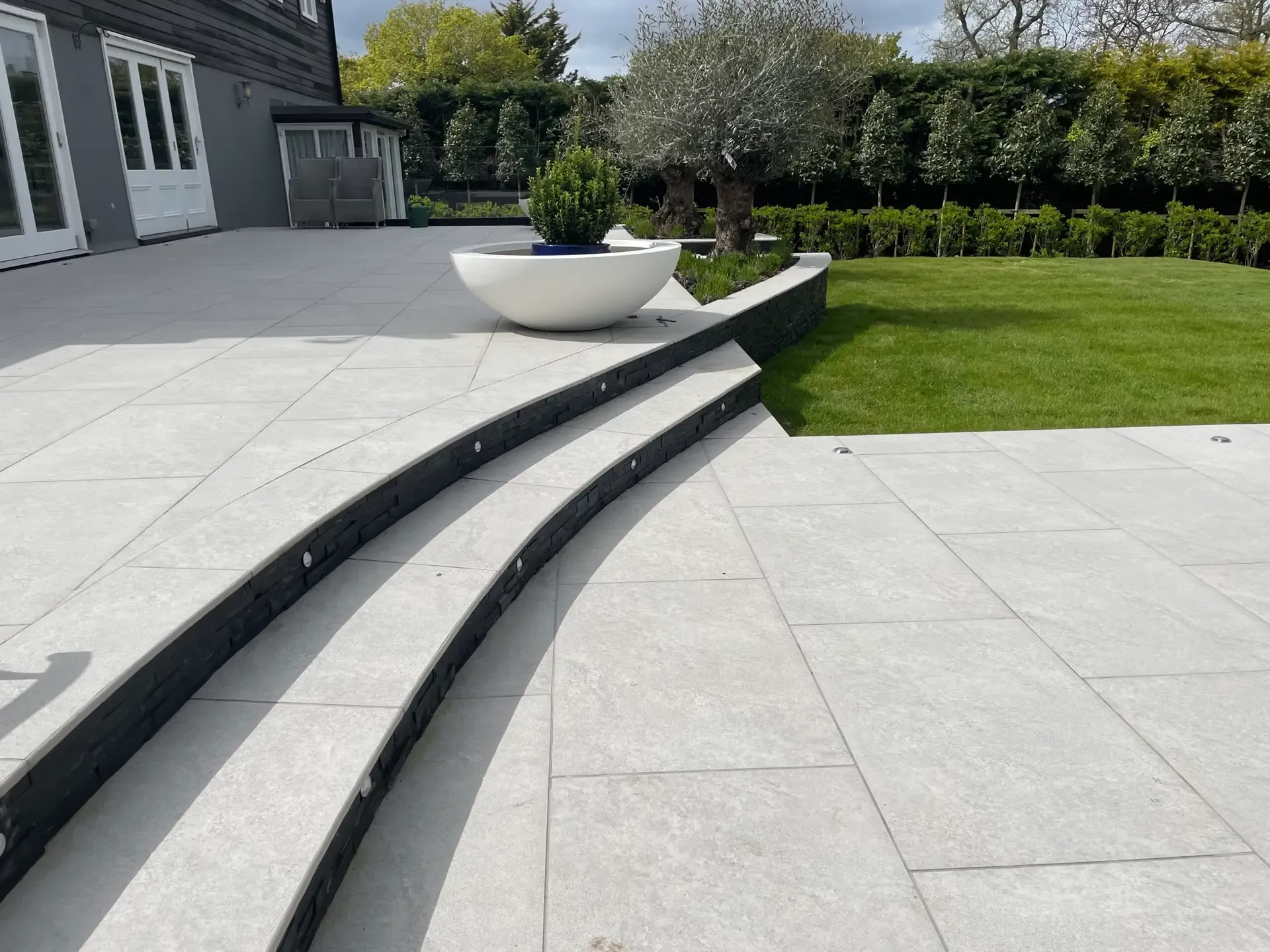Porcelain terrace with discreet stainless steel drainage detail in Danbury garden