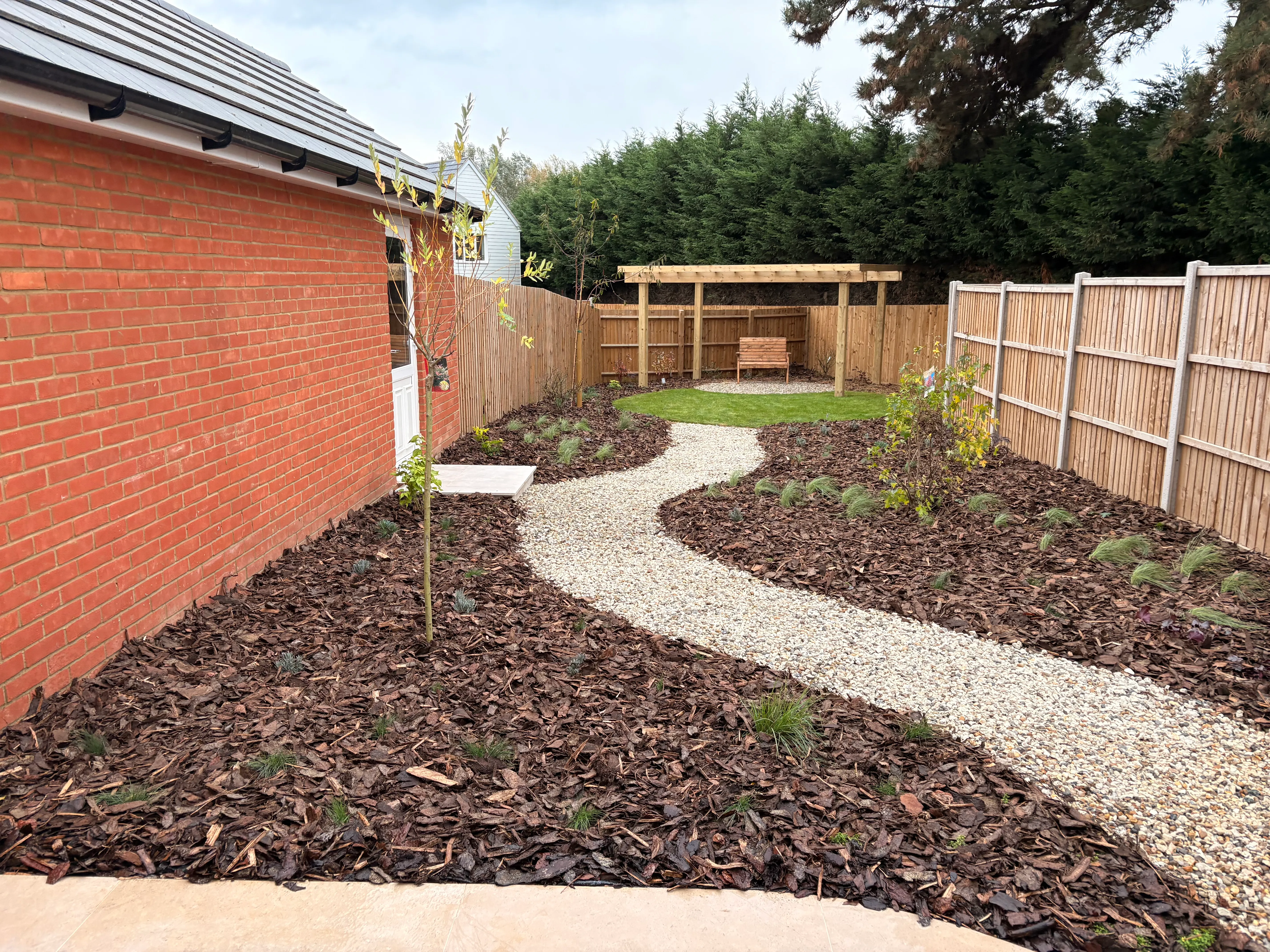 Curved gravel path running between fresh planting beds in a Kelvedon new-build garden